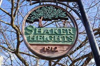 a sign for shaker heights in front of a tree